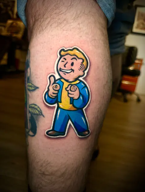 Tatuaje a color de Vault Boy en la pierna