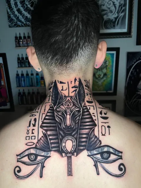 Tatuaje de Anubis y ojos de Horus en la nuca