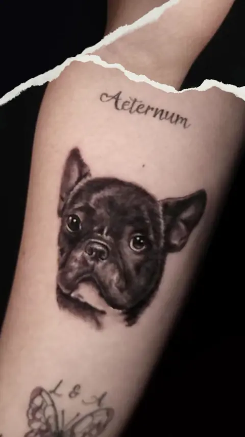 Retrato realista de un bulldog francés en el antebrazo